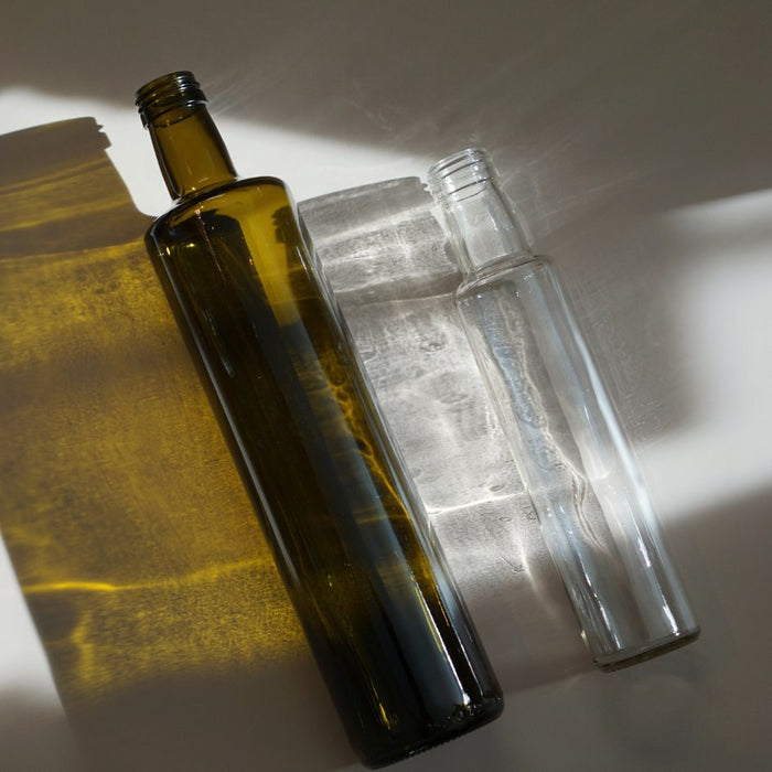 oljeflaskor i brun och klart glas i olika storlekar